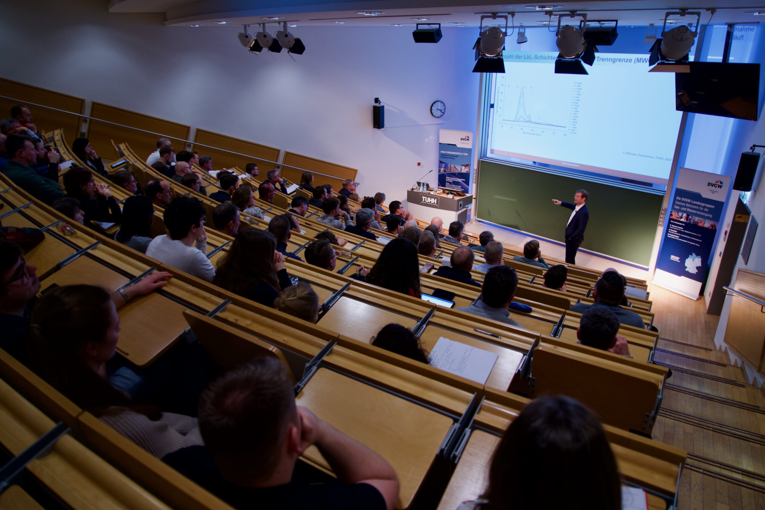 The photo shows Professor Mathias Ernst in the lecture hall at the TUHH in front of an interested audience.