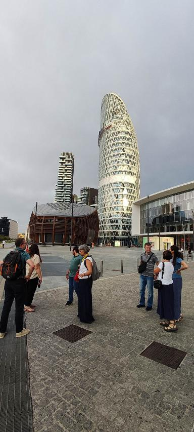 A group of people on a place in Milan in front of a skyscraper.